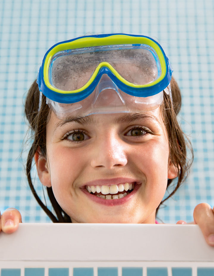 Photo lifestyle enfant petite fille dans son bain à jouer avec l'eau